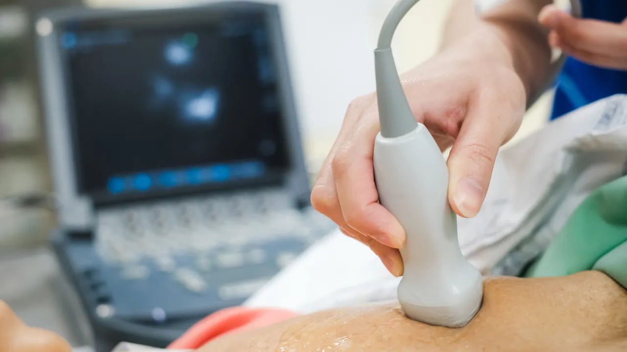 An ultrasound probe held against a patient's chest during an echocardiogram