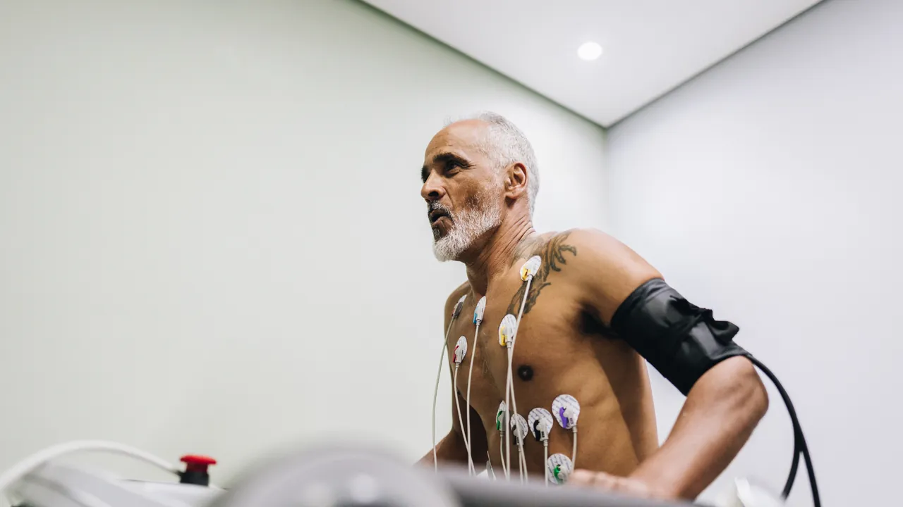 A man exercising with ECG leads and a blood pressure cuff attached